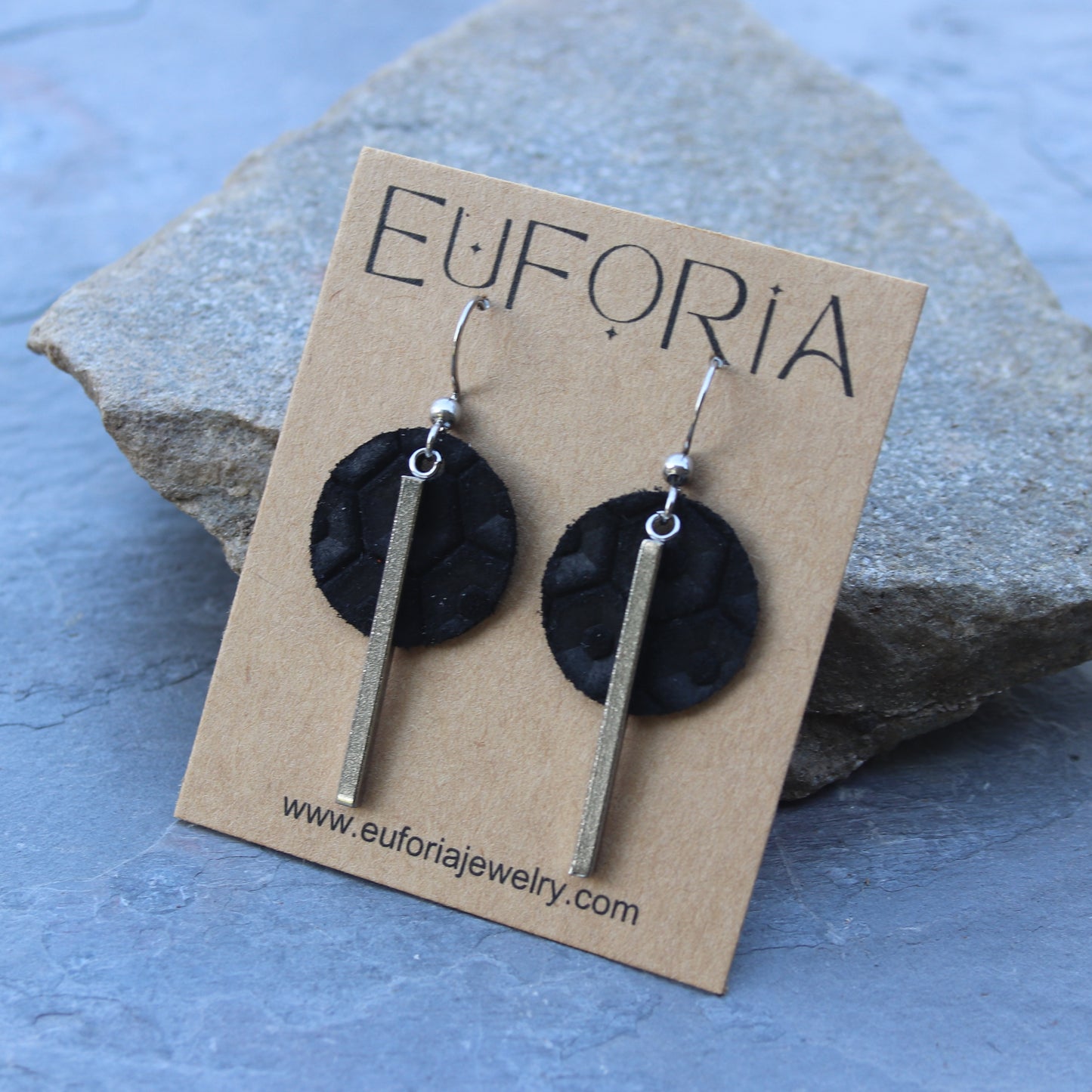 .75" black leather circles with 1.5" stainless steel bar charm overlaid. 2" total length dangle earrings.