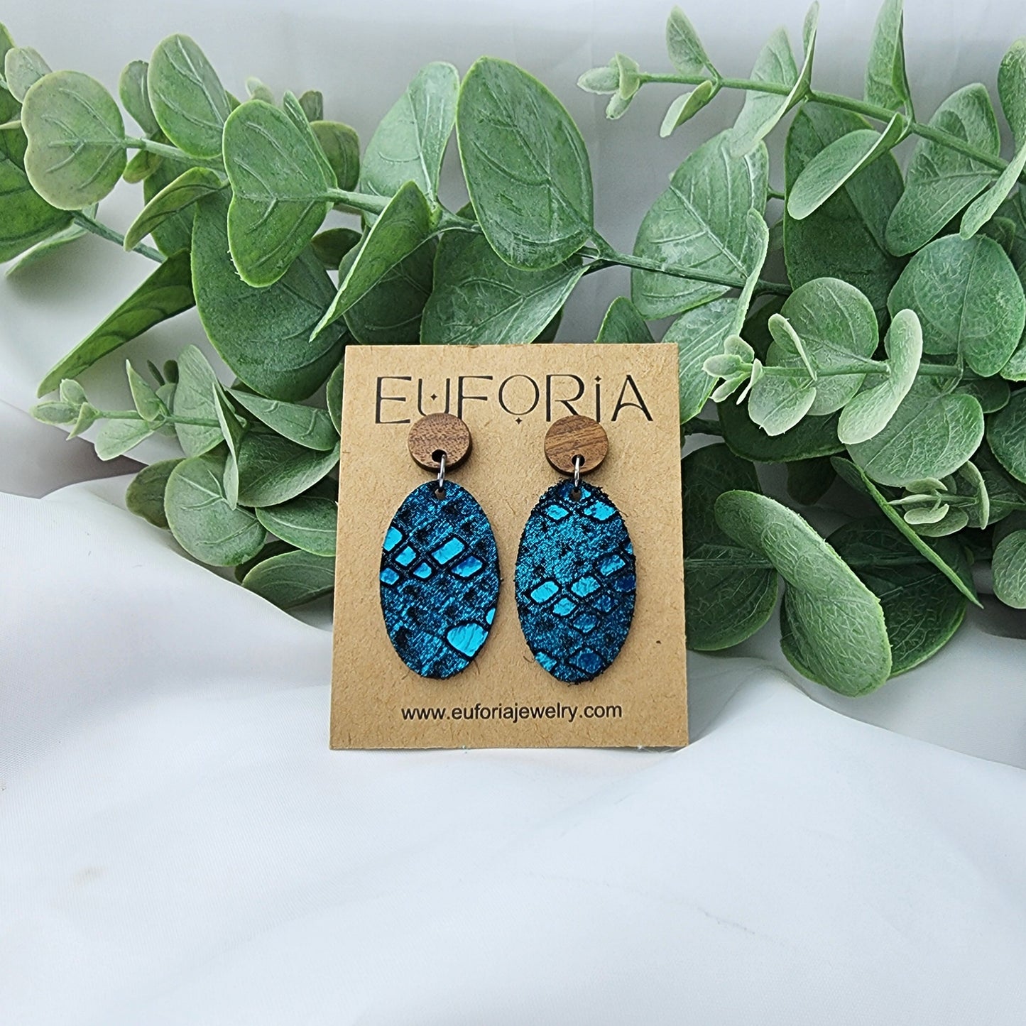 leather oval earrings with round wood post. 1.25" ovals with metallic teal snakeskin print over black.