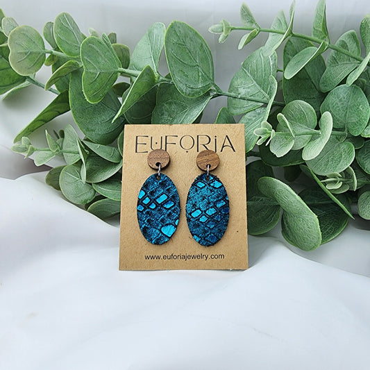 leather oval earrings with round wood post. 1.25" ovals with metallic teal snakeskin print over black.