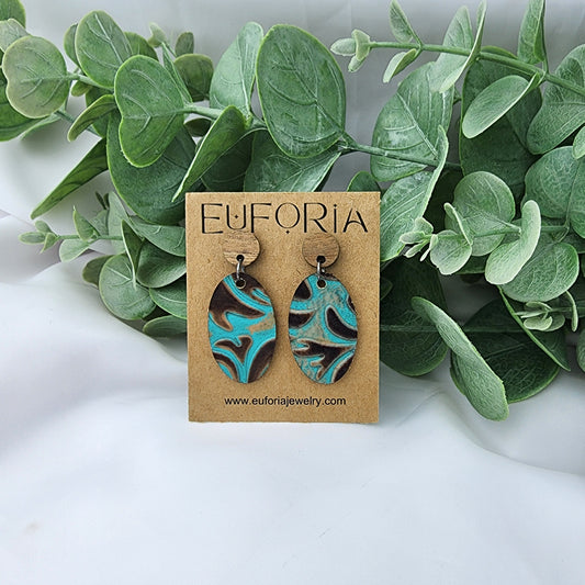 leather oval earrings with round wood post. 1.25" ovals in turquoise and brown western tool print