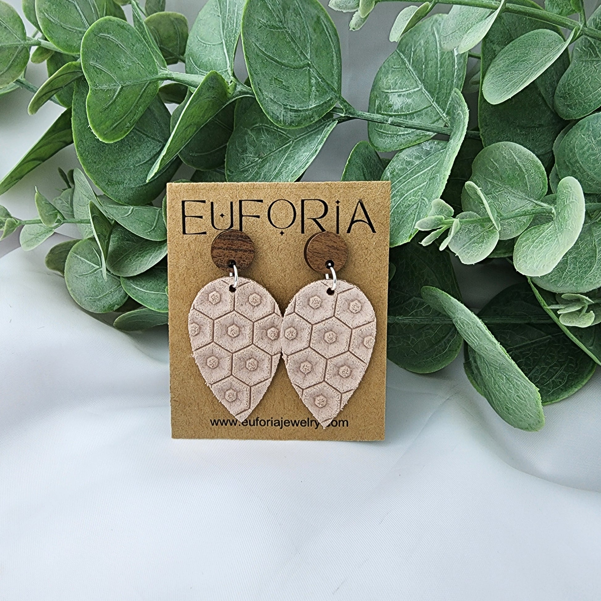 Leather teardrop earrings with round wood post. Light pink with beehive texture.