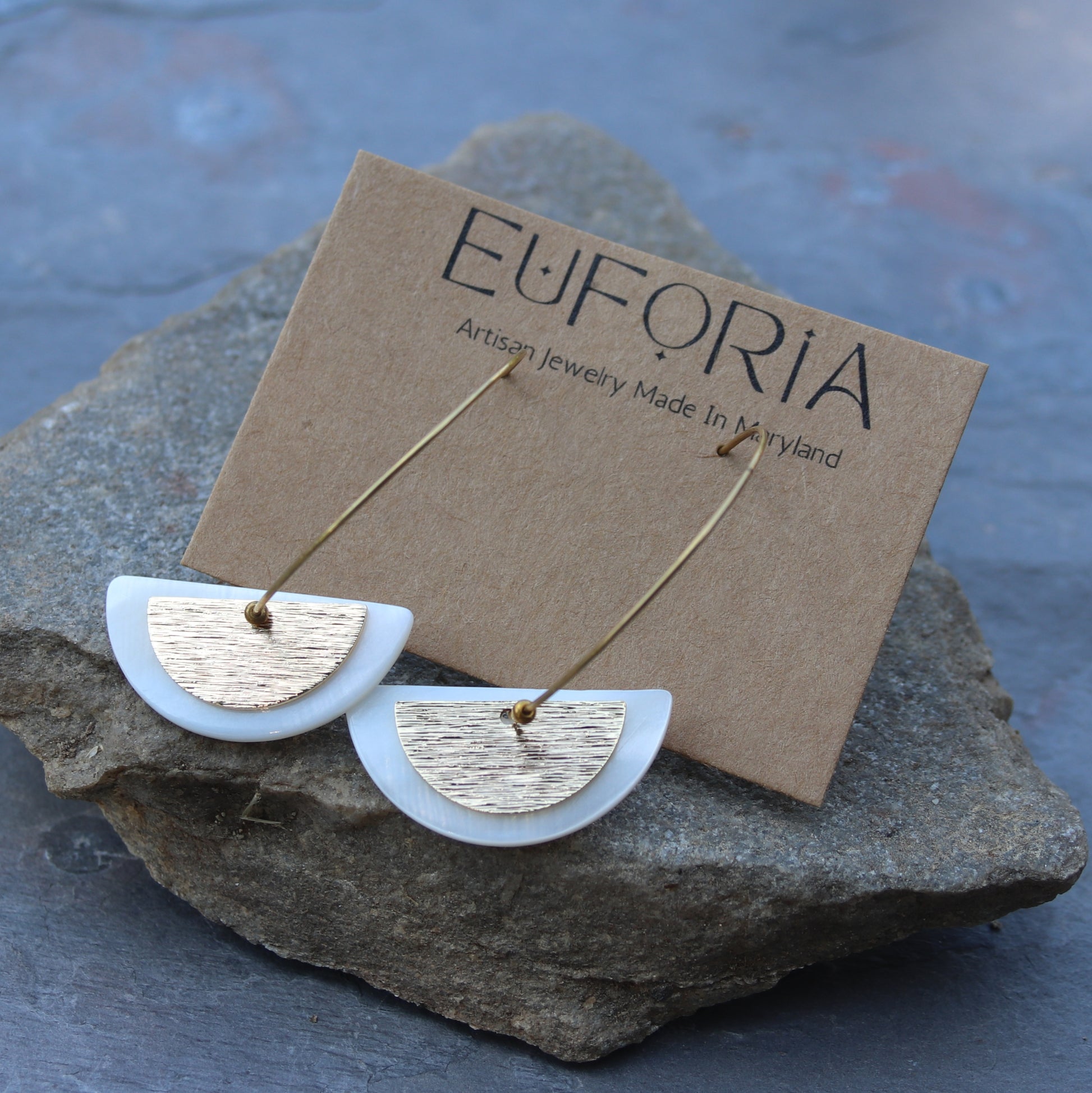 Layered half circle shell and brass charms on brass hoop. Total length 2"