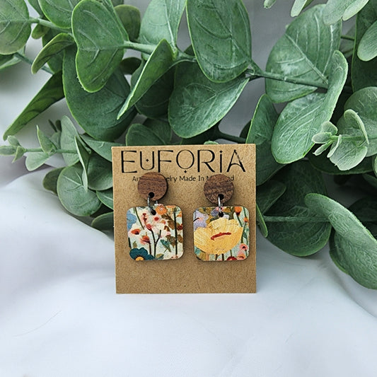 Cork over leather square earrings with round wood post. .75" squares of cheerful wildflowers - each pair is different..