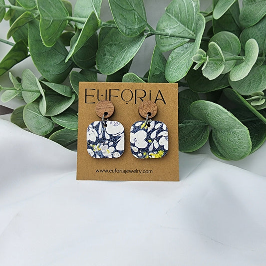 Cork over leather square earrings with round wood post. .75" squares white and light aqua floral over a navy blue field.
