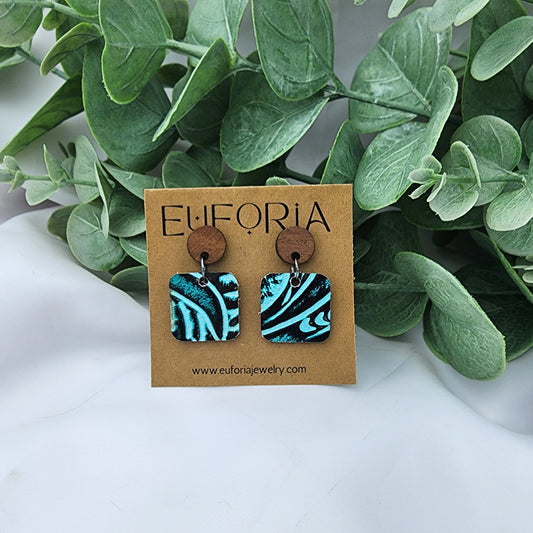 leather square earrings with round wood post. .75" squares in western tooled aqua and black pattern.