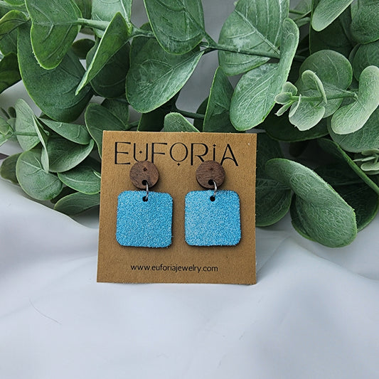 leather square earrings with round wood post. .75" squares in aqua dazzle color.