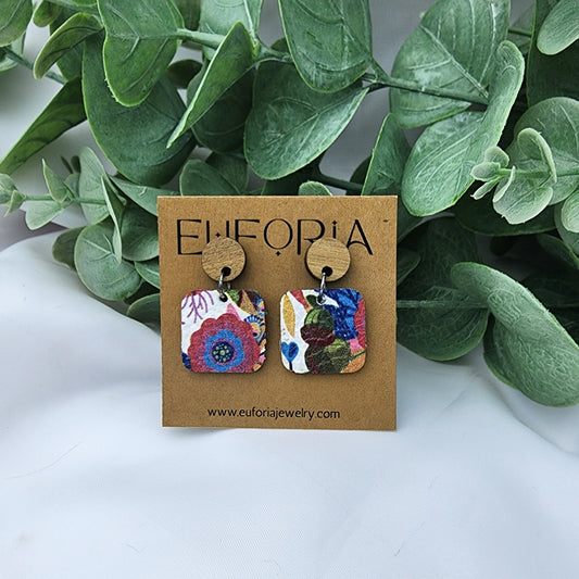 leather square earrings with round wood post. .75" squares in a muted primary color bold floral over white field.