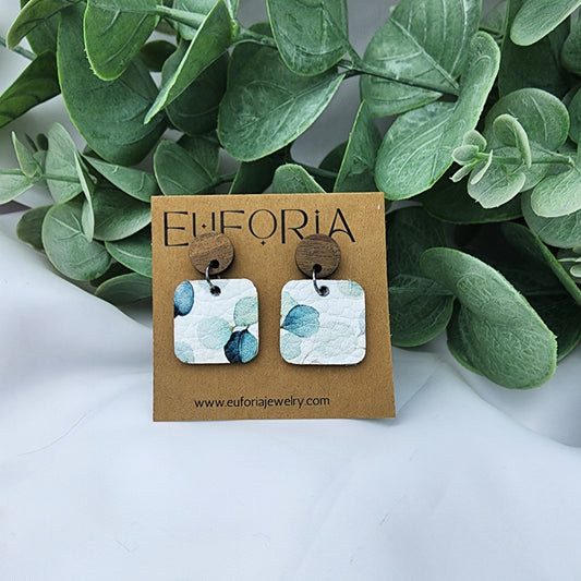 leather square earrings with round wood post. .75" squares  with water color style green leaves over white.
