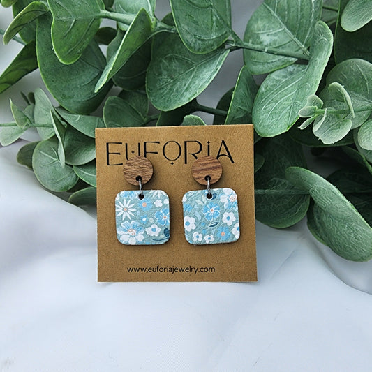 leather square earrings with round wood post. .75" squares in white floral over seafoam field.