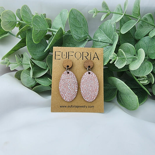 leather oval earrings with round wood post.  1.25" ovals with tiny holographic dots over light pink..