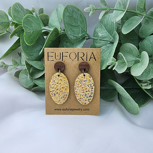 leather oval earrings with round wood post. 1.25" ovals with holographic layer over tan
