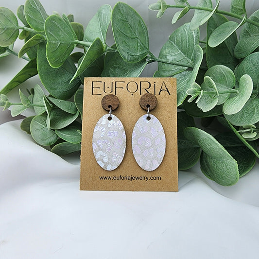 leather oval earrings with round wood post. 1.25" ovals with holographic leopard print over white