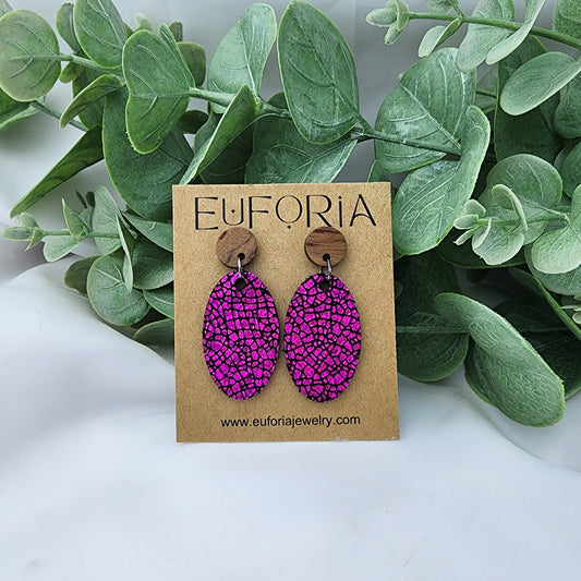 leather oval earrings with round wood post. 1.25" ovals with a hot pink holographic layer over black