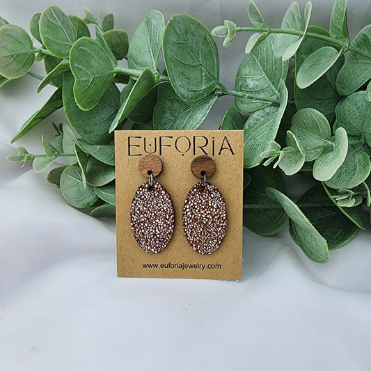 leather oval earrings with round wood post. 1.25" ovals with tiny holographic dots over dark tan
