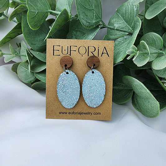 leather oval earrings with round wood post.  1.25" ovals with tiny holographic dots over light aqua