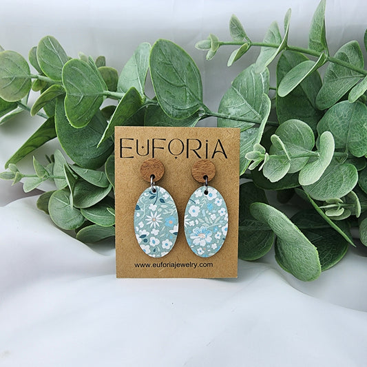 leather oval earrings with round wood post. 1.25" ovals with white floral over seafoam