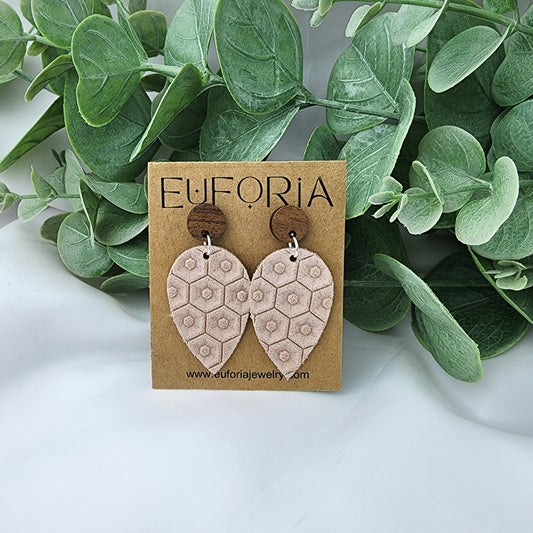 Leather teardrop earrings with round wood post. Light pink with beehive texture.
