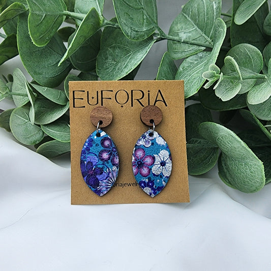 leather oval earrings with round wood post. 1.25" ovals with silver and purple floral over aqua