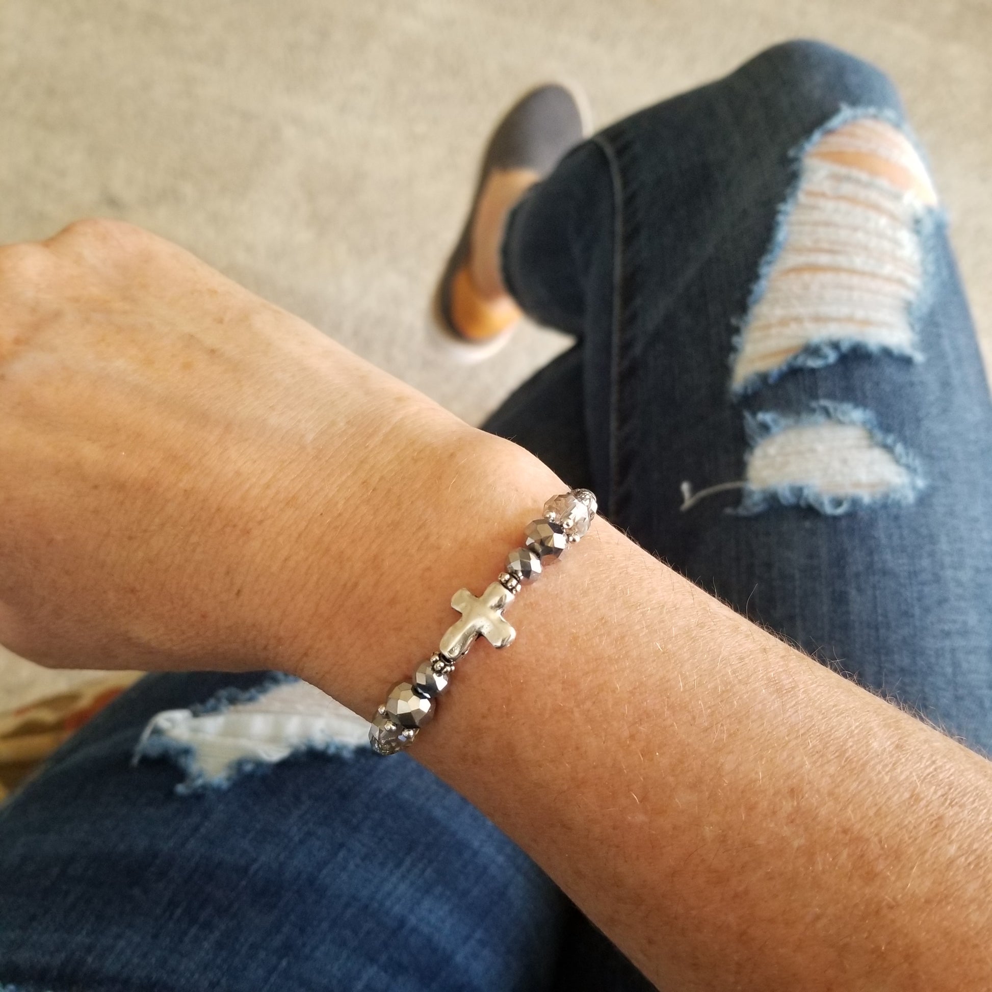 silver cross charm and coordinating faceted glass beads wrap bracelet on wrist