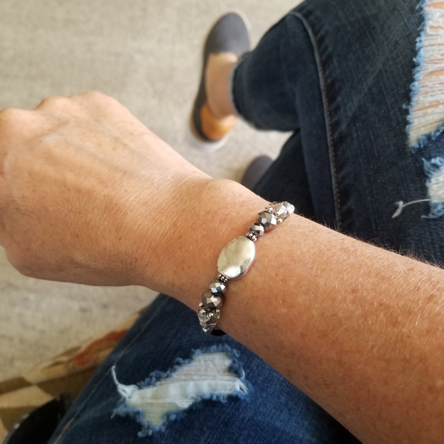 Silver organic shaped oval charm with coordinating glass beads wrap bracelet on wrist